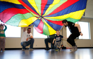 Children and parents running under a parachute